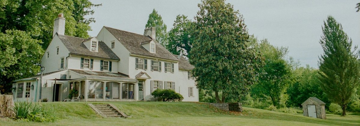 A white farmhouse with a beautifully trimmed lawn is protected by the NH homestead exemption.