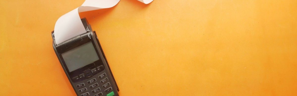 A calculator sits on an orange background representing unexpected closing costs in New Hampshire. (thin)